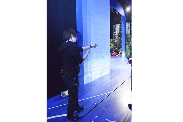 舞台装置を操りながら、舞台袖から舞台上を見守る渋谷さん。