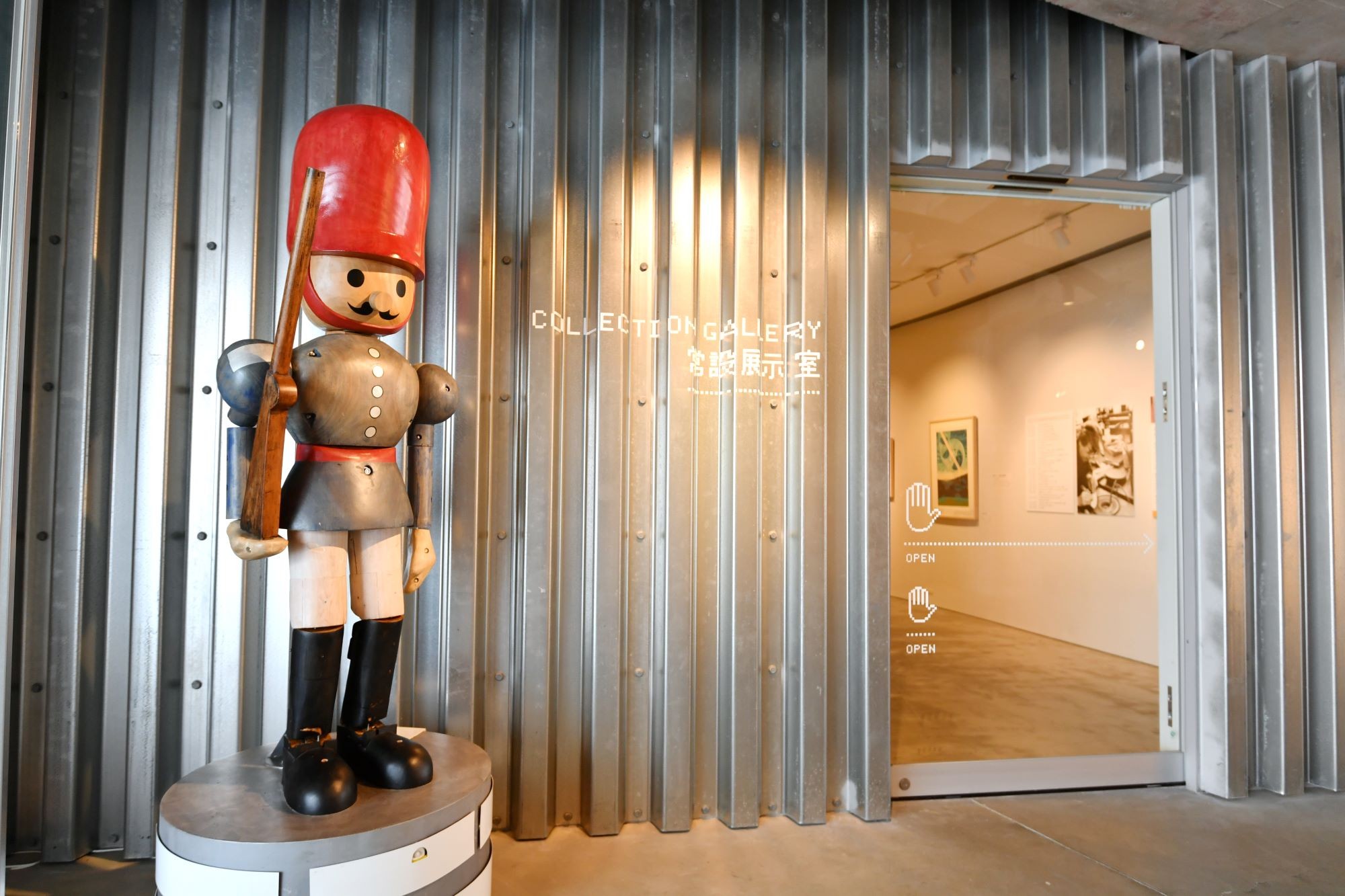 常設展示室前にある同館の恒久作品《Toy Soldier》KOSUGE1-16, 2013　 美術館の監視員として派遣されたおもちゃの兵隊で、人が通るとピシっと警備する。