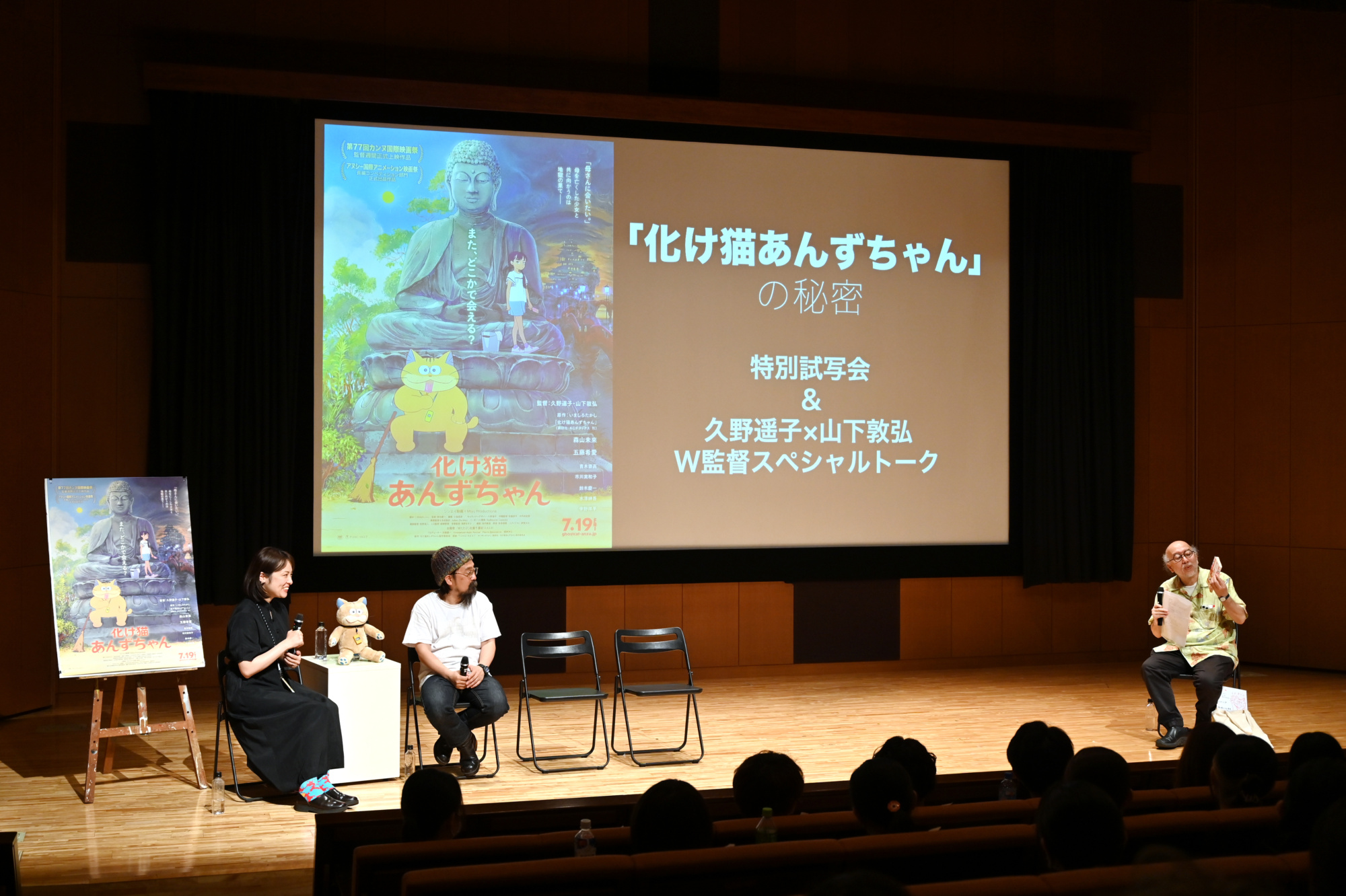特別試写会後のトーク会で、大型スクリーンを背に左から久野遥子監督、山下敦弘監督、野村辰寿教授がステージ上で椅子に座り、観客に向かって話している